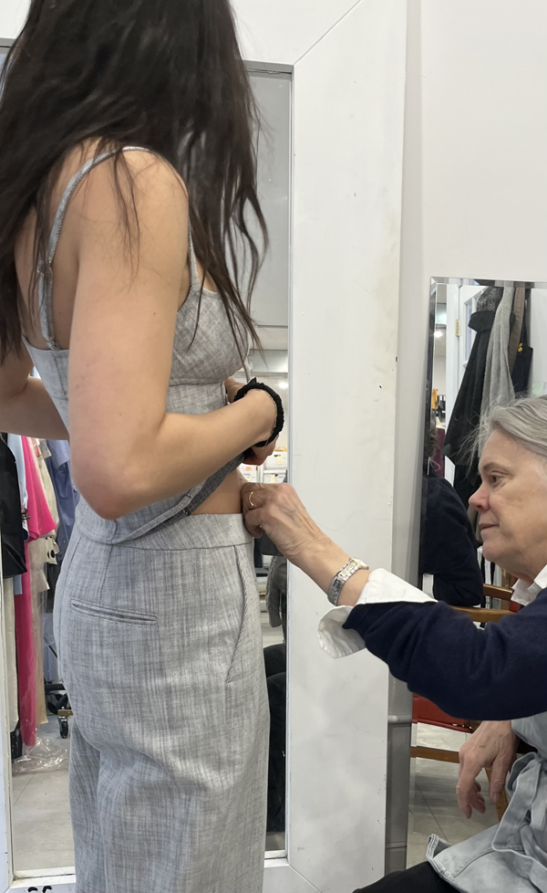 Elizabeth evaluating the fit of a new pair of pants on a fit model.